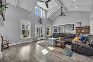 Great room with beamed ceiling, a healthy amount of sunlight, ceiling fan, and light LVP flooring