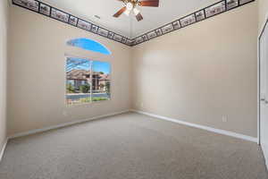 Empty room featuring ceiling fan and carpet