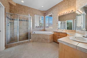 Bathroom featuring vanity and independent shower and bath