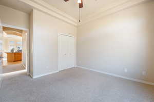 Unfurnished room with light carpet, ceiling fan, and a high ceiling