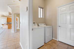 Laundry area with light tile patterned flooring and washer and clothes dryer