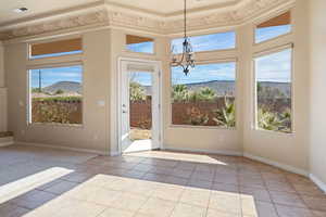 Interior space featuring a mountain view, light tile patterned floors, and a notable chandelier