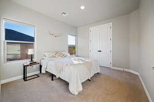 Carpeted bedroom featuring a closet