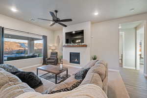 Living room featuring ceiling fan and light hardwood / wood-style flooring