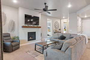 Carpeted living room featuring ceiling fan