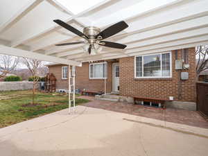 View of front of house featuring ceiling fan, a front lawn, and a patio