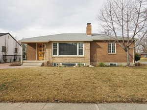 Ranch-style home featuring a front lawn