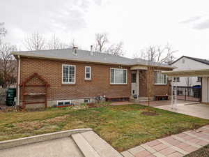 Rear view of property with a yard and a patio area