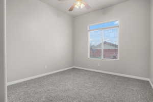 Carpeted empty room with ceiling fan