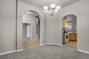 Interior space featuring sink, light colored carpet, and a chandelier