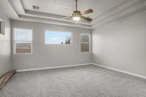 Unfurnished room featuring ceiling fan, a raised ceiling, carpet floors, and a textured ceiling