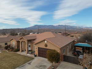 View of front of home featuring a garage, a mountain view, and a front yard