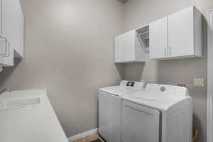 Washroom featuring cabinets, washer and clothes dryer, and sink