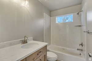 Full bathroom with vanity, bathtub / shower combination, and toilet