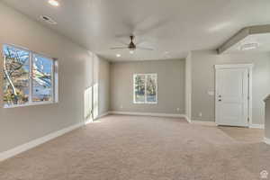 Carpeted spare room featuring ceiling fan