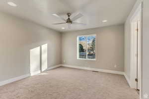 Carpeted empty room with ceiling fan