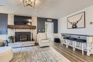 Living room featuring wood-type flooring and a textured ceiling