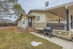 Back of house with a yard and a patio area