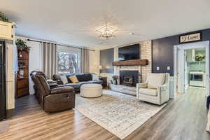 Living room with wood-type flooring, washer / clothes dryer, and a textured ceiling