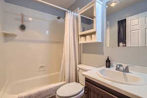 Full bathroom featuring vanity, toilet, and shower / bath combo with shower curtain