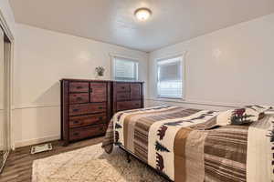 Bedroom featuring wood-type flooring, a closet, and a textured ceiling