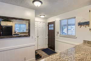 Foyer entrance with sink, wood-type flooring, and a textured ceiling