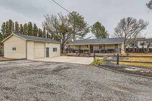 Rear view of house featuring a garage and an outdoor structure