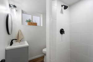 Bathroom with vanity, toilet, and tiled shower