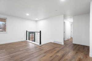 Empty room featuring dark hardwood / wood-style floors