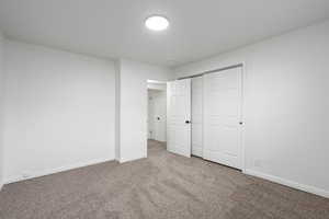 Unfurnished bedroom with carpet flooring and a closet