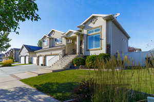 View of front of property with a garage and a front lawn