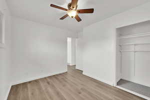 Unfurnished bedroom featuring ceiling fan, light hardwood / wood-style floors, and a closet