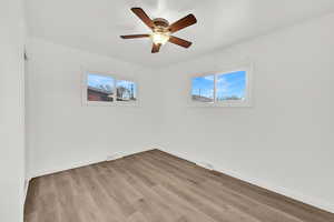 Empty room with ceiling fan and light wood-type flooring