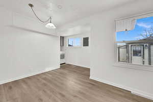 Unfurnished room featuring wood-type flooring, washer / dryer, and electric panel