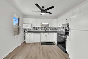 Kitchen featuring sink, white cabinetry, light wood-type flooring, white appliances, and decorative backsplash