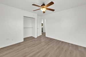 Unfurnished bedroom featuring ceiling fan, light hardwood / wood-style floors, and a closet