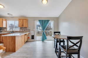 Kitchen with a healthy amount of sunlight, decorative backsplash, LVP style floors, and kitchen peninsula