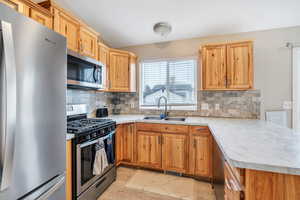 Kitchen with tasteful backsplash, stainless steel appliances, and sink