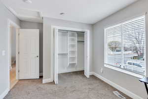 Unfurnished bedroom featuring light colored carpet and a closet