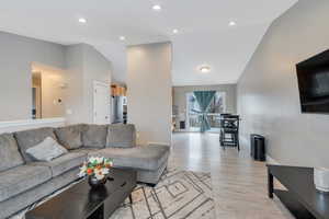 Living room with lofted ceiling and light hardwood / wood-style floors