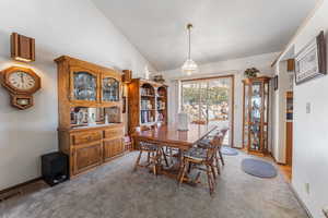 Dining room with carpet and high vaulted ceiling