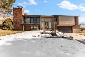 View of front of home with a garage and a balcony