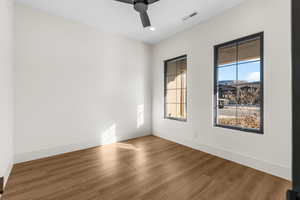 Unfurnished room with ceiling fan and hardwood / wood-style flooring