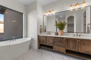 Bathroom with a washtub and vanity