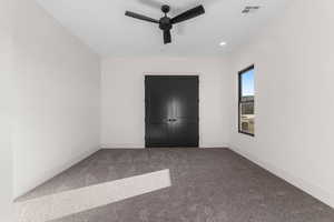 Unfurnished bedroom with ceiling fan, a closet, and carpet