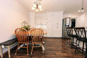 Dining space with dark hardwood / wood-style floors and a chandelier