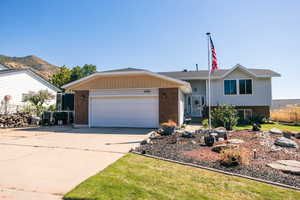 The front of the home features a mountain view, RV parking, and a garage. Photo taken last Fall.