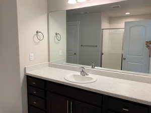 Bathroom with a shower with door and vanity