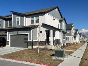 View of front facade with a residential view, driveway, and an attached garage