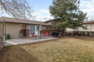 Rear view of property featuring an outdoor fire pit, a yard, and a patio area